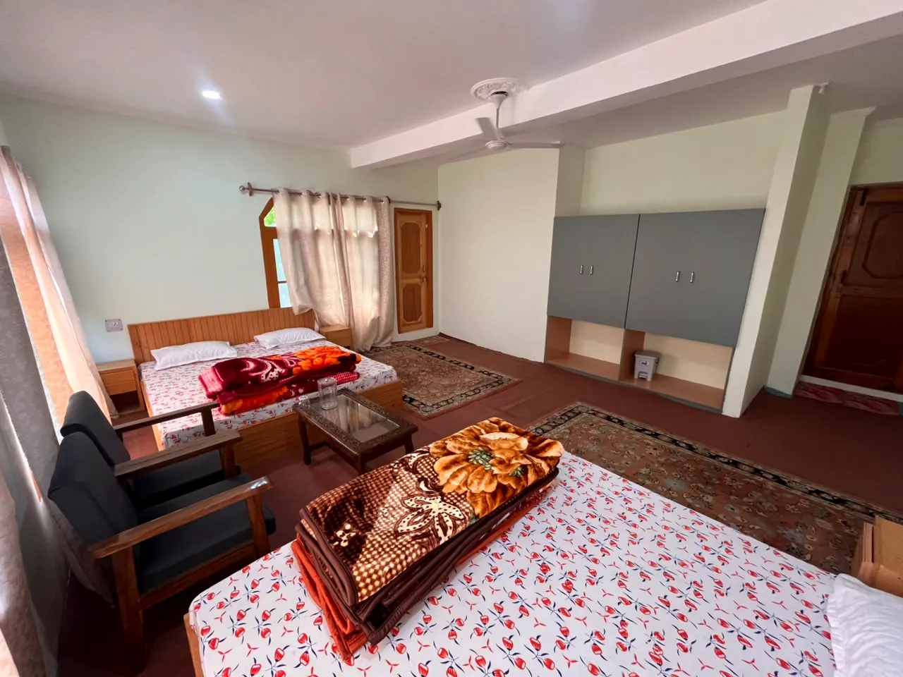 Polaris — a generous room with beds, chairs and a wide rug